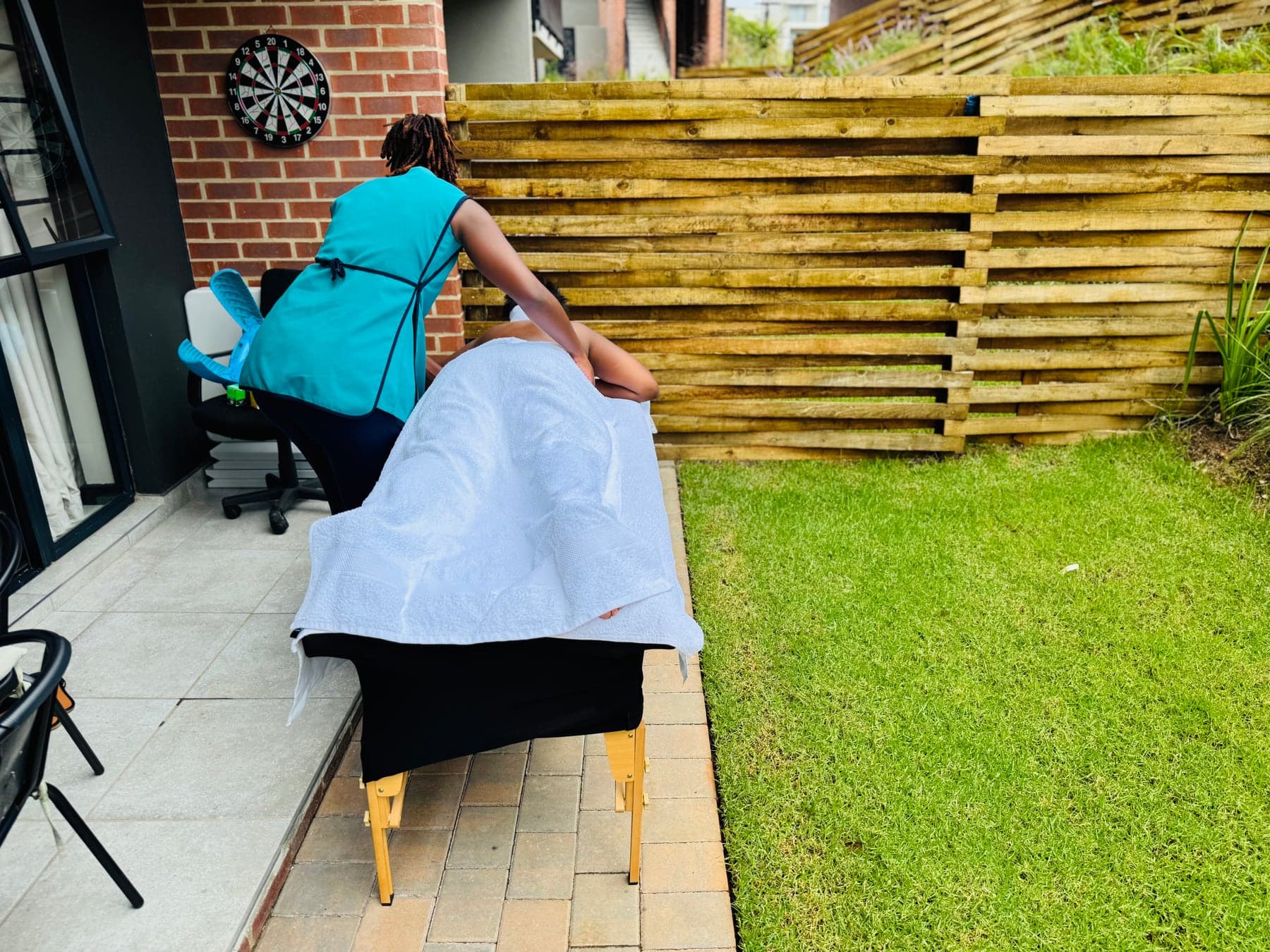 Mia Wellness Spa therapist providing a treatment beside a private outdoor home setup.